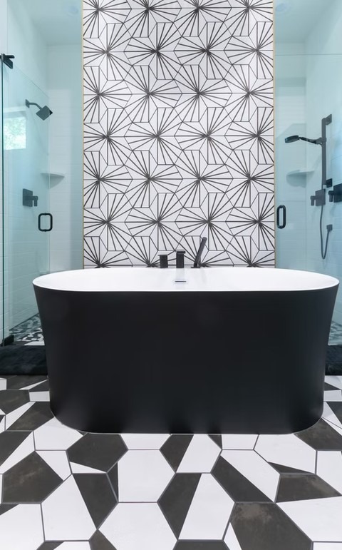 Luxury master bathroom featuring a freestanding white soaking tub, floor-to-ceiling marble tile, and a spacious glass-enclosed shower.