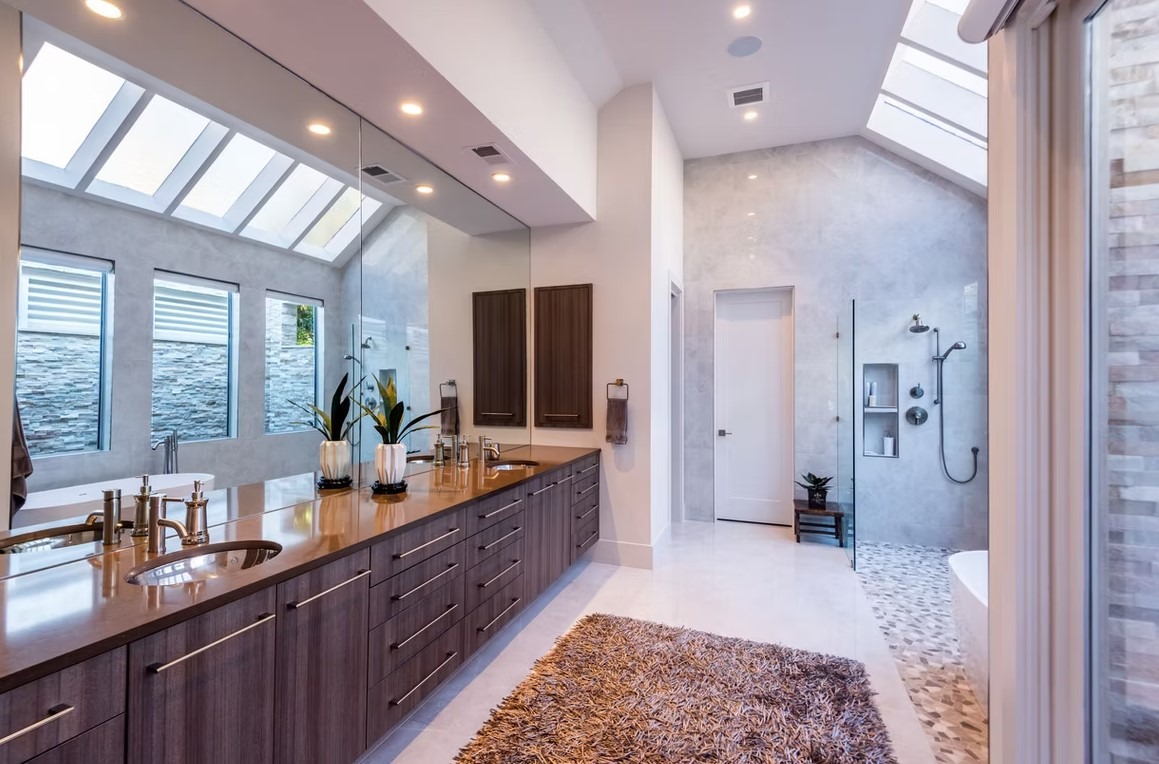 Luxury master bathroom walk-in shower featuring floor-to-ceiling marble tile, a frameless glass enclosure, and a built-in stone bench.