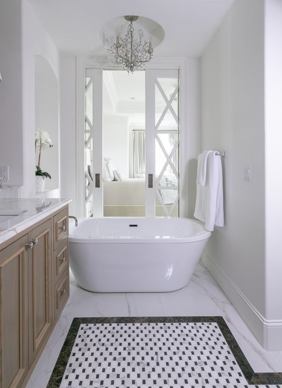 Luxury bathroom vanity featuring white cabinetry, a thick marble countertop, and large rectangular mirrors with contemporary vanity lighting.