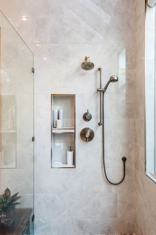 High-end bathroom vanity with dual sinks, white shaker-style cabinetry, and a thick marble countertop featuring grey veining.