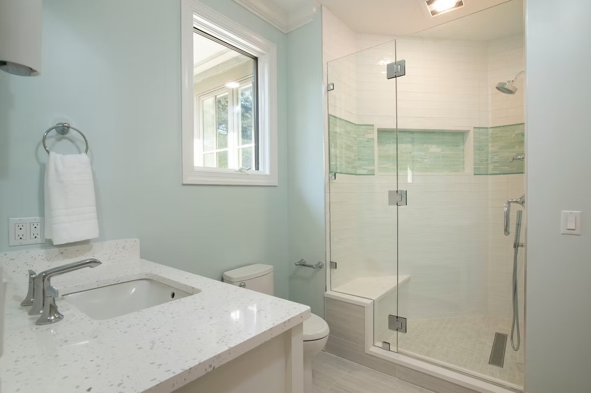 Luxury bathroom vanity with white shaker-style cabinetry, dual undermount sinks, and a thick marble countertop featuring grey veining.