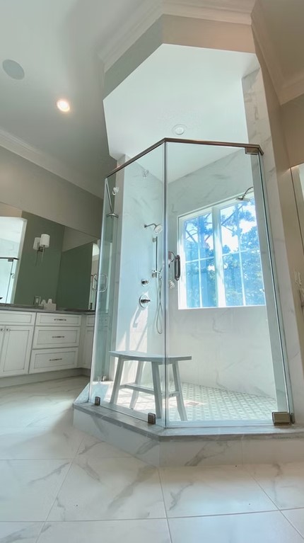 High-end bathroom vanity featuring dual sinks, custom white cabinetry, and a thick marble countertop with elegant grey veining.