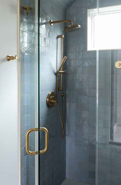 Luxury master bathroom walk-in shower featuring floor-to-ceiling marble tile, a frameless glass enclosure, and a built-in stone bench.