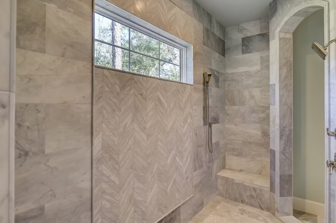 High-end bathroom vanity featuring dual sinks, custom white cabinetry, and a thick marble countertop with elegant gray veining.