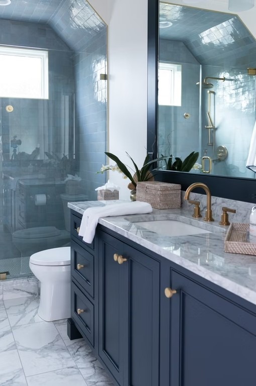 Luxury master bathroom featuring a freestanding white soaking tub, floor-to-ceiling marble tile, and a spacious glass-enclosed shower.