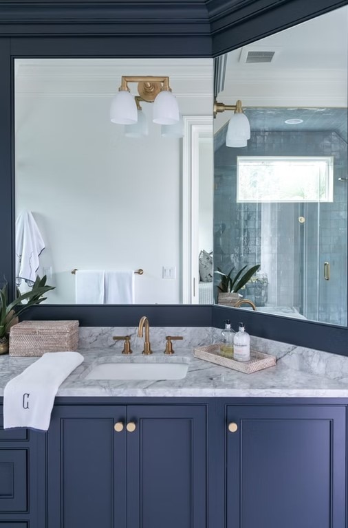 Luxury master bathroom walk-in shower with floor-to-ceiling marble tile, a frameless glass enclosure, and a built-in stone bench.