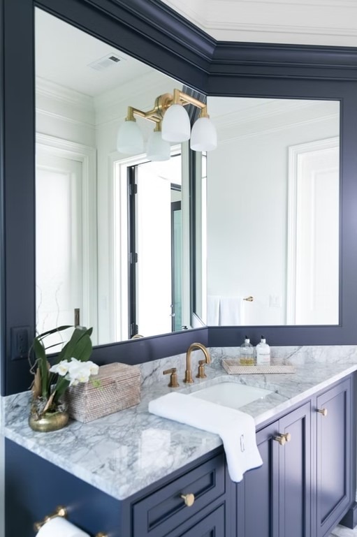 Luxury bathroom vanity featuring dual sinks, white custom cabinetry, and a thick marble countertop with elegant grey veining.