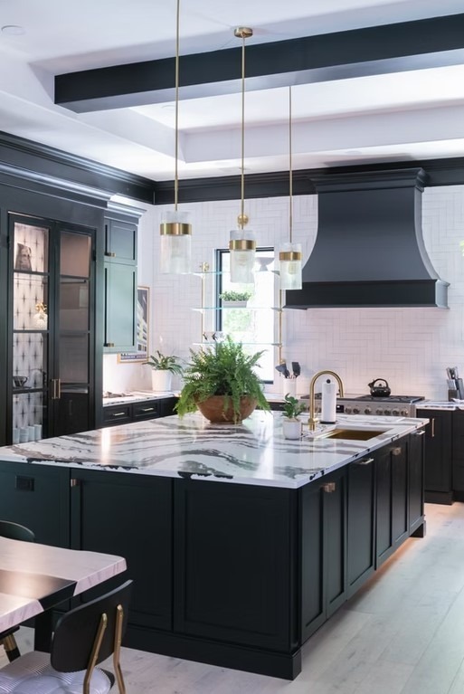 Transitional luxury kitchen with a large dark wood island, white perimeter cabinetry, and elegant lantern pendant lights.