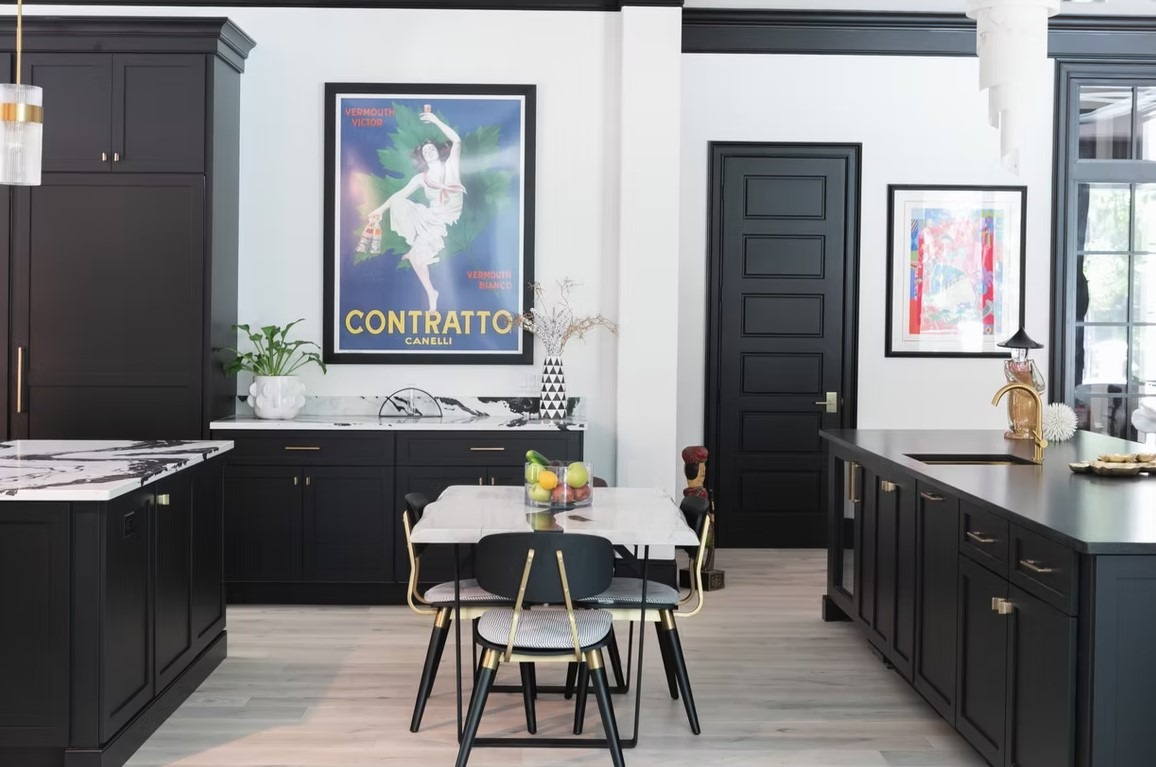 Modern upscale kitchen featuring a matte black island, light oak cabinetry, and a white marble waterfall countertop.
