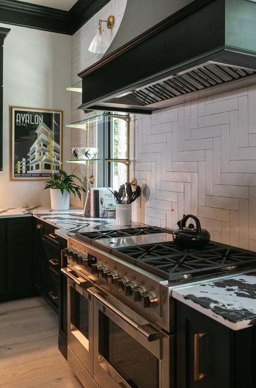 Elegantly designed kitchen featuring a spacious white island with a prep sink, classic pendant lighting, and a detailed coffered ceiling.