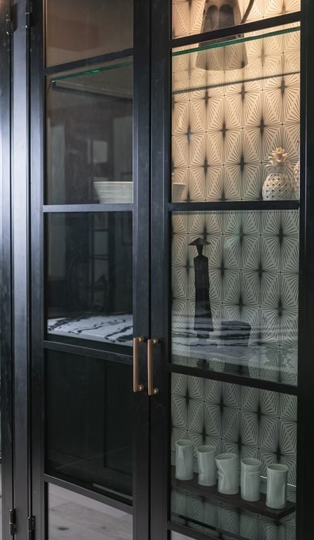 Luxury kitchen with a focus on a professional gas range, ornate custom cabinetry, and a decorative tile focal point above the stove.