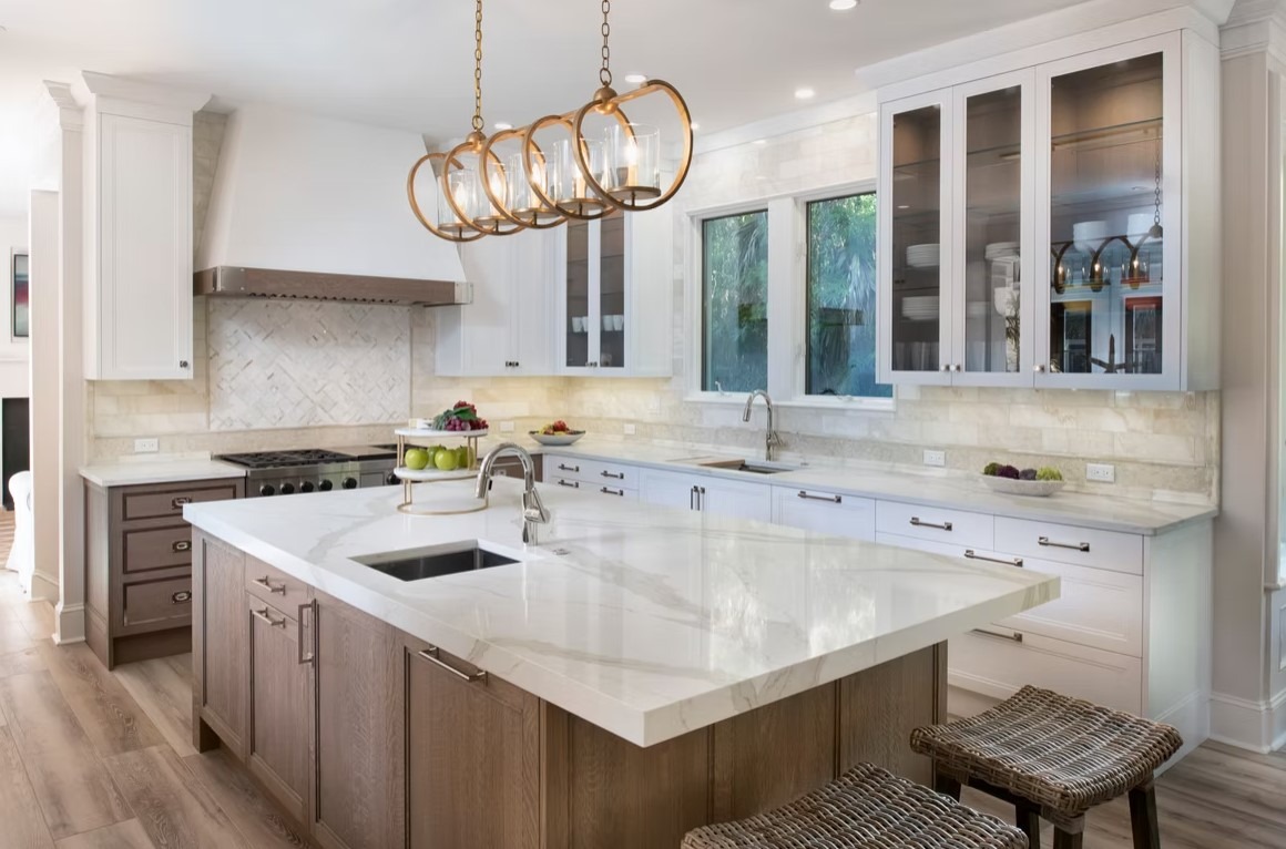 Modern luxury kitchen featuring a sleek marble backsplash, professional-grade range, and minimalist cabinetry in a warm wood finish.