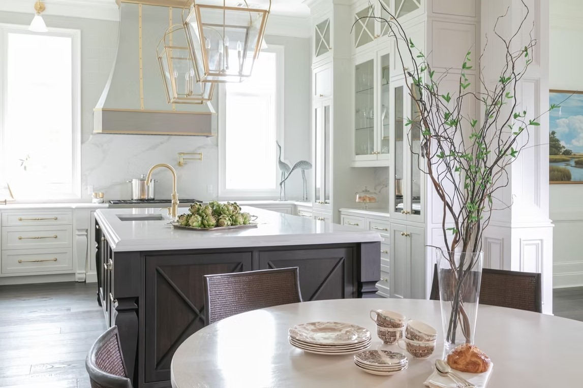 Transitional luxury kitchen showcasing a large gray center island with a breakfast bar, white perimeter cabinetry, and modern silver pendant lights.