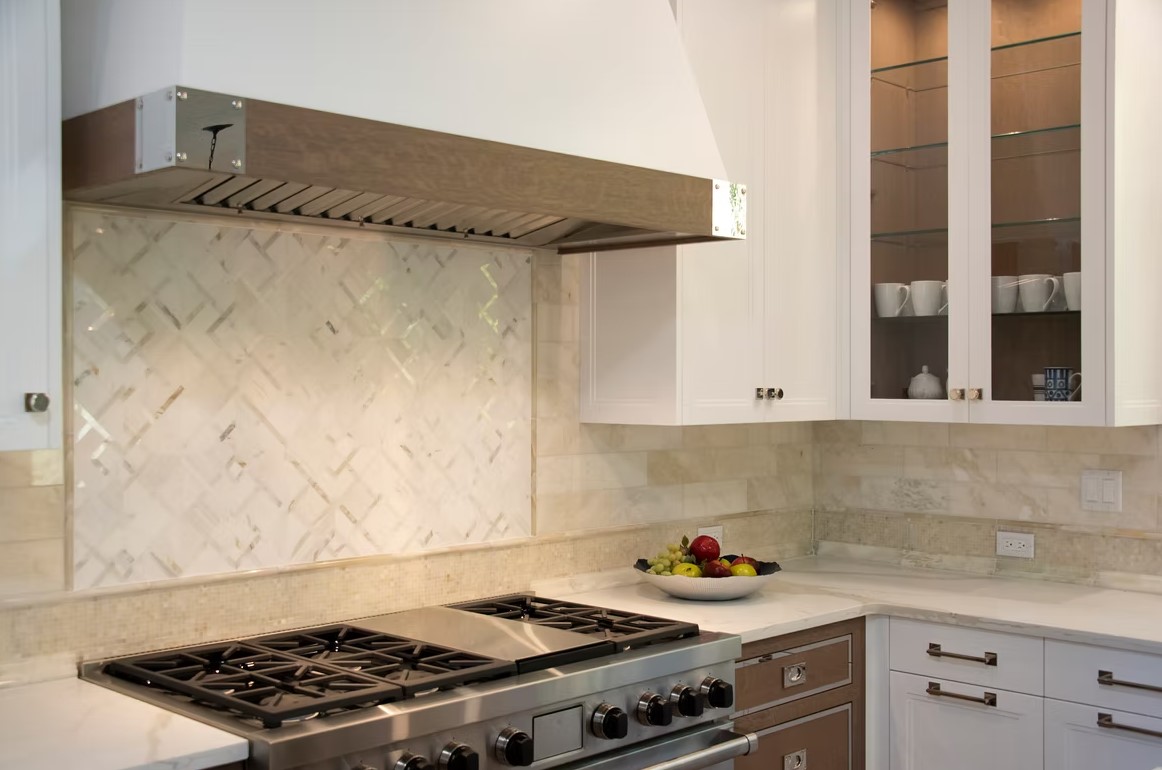 Luxury custom kitchen featuring a massive stone-topped island, bespoke cabinetry, and contemporary pendant lighting.