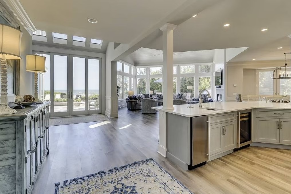 Luxury custom kitchen featuring a massive stone-topped island, bespoke cabinetry, and contemporary pendant lighting.