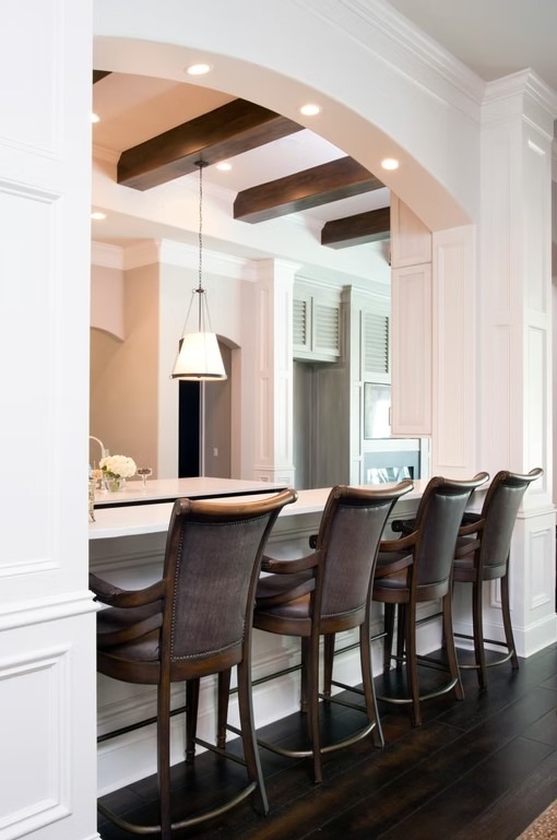 Luxury custom kitchen featuring a massive stone-topped island, bespoke cabinetry, and contemporary pendant lighting.