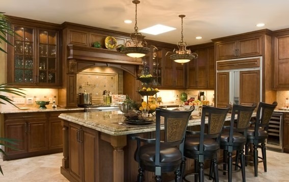 Luxury custom kitchen featuring a massive stone-topped island, bespoke cabinetry, and contemporary pendant lighting.