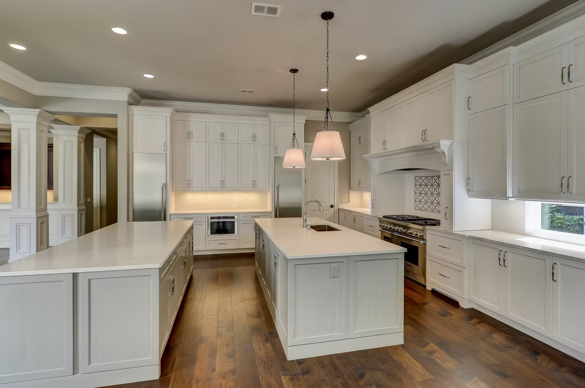 Luxury custom kitchen featuring a massive stone-topped island, contemporary cabinetry, and professional-grade appliances by Palatial Homes.