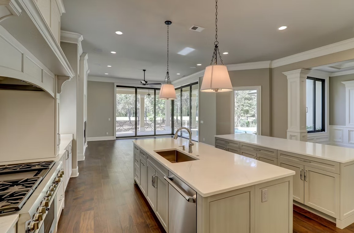 Luxury custom kitchen featuring elegant cabinetry, a large stone-topped center island, and high-end integrated appliances.