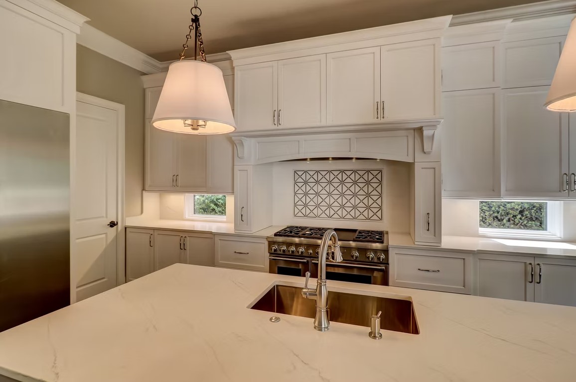 Luxury custom kitchen featuring sleek cabinetry, a large stone-topped center island, and high-end integrated appliances.