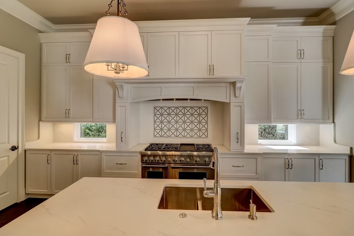 Luxury custom kitchen featuring premium cabinetry, a massive stone-topped center island, and contemporary lighting by Palatial Homes.