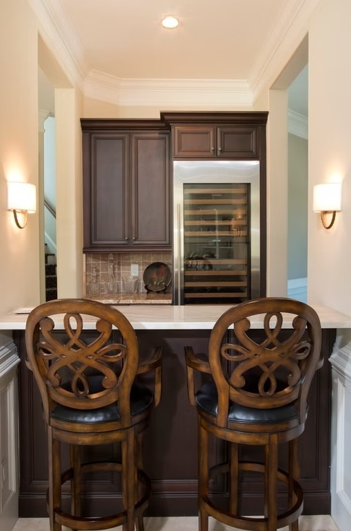 Luxury custom kitchen featuring elegant white cabinetry, a large marble-topped center island, and professional-grade stainless steel appliances.