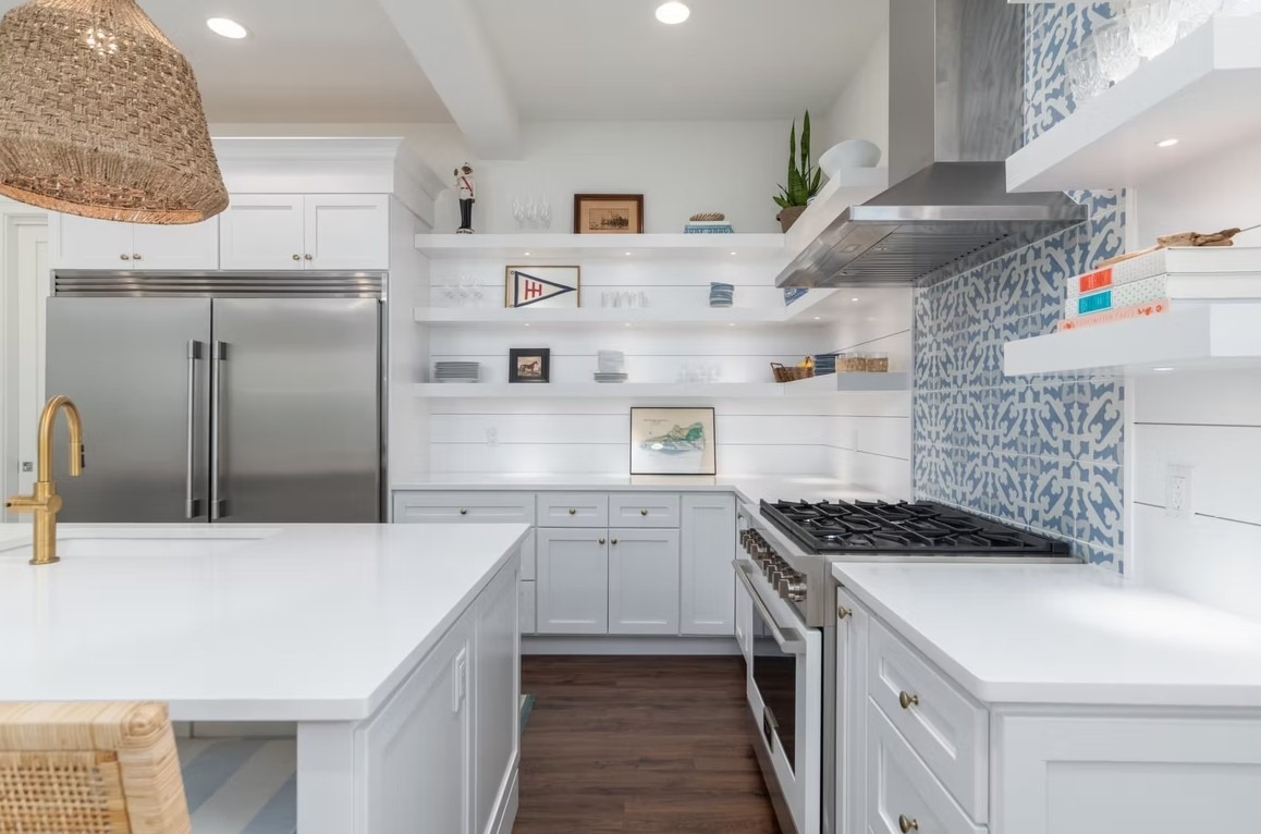 Luxury custom kitchen featuring professional-grade appliances, an expansive center island with a stone countertop, and contemporary pendant lighting.