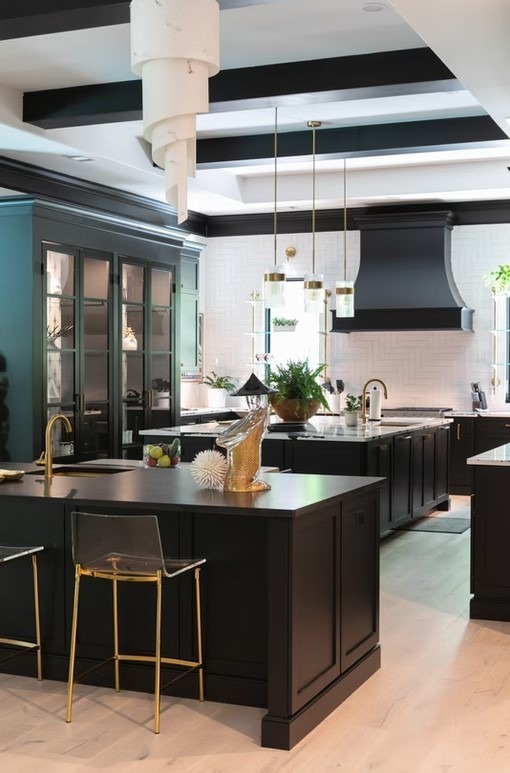 Transitional luxury kitchen featuring a large gray center island with a breakfast bar, white perimeter cabinetry, and modern silver pendant lights.