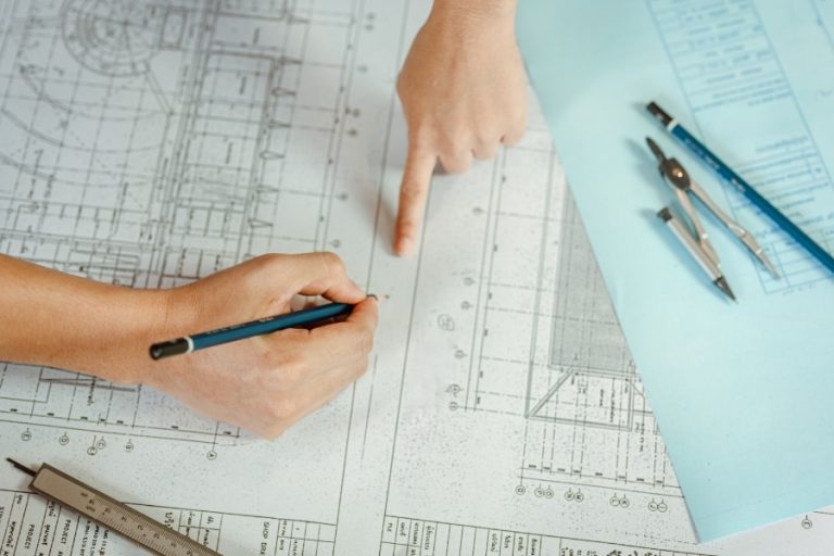 Homeowner and custom home builder collaborating on architectural blueprints during a design consultation.
